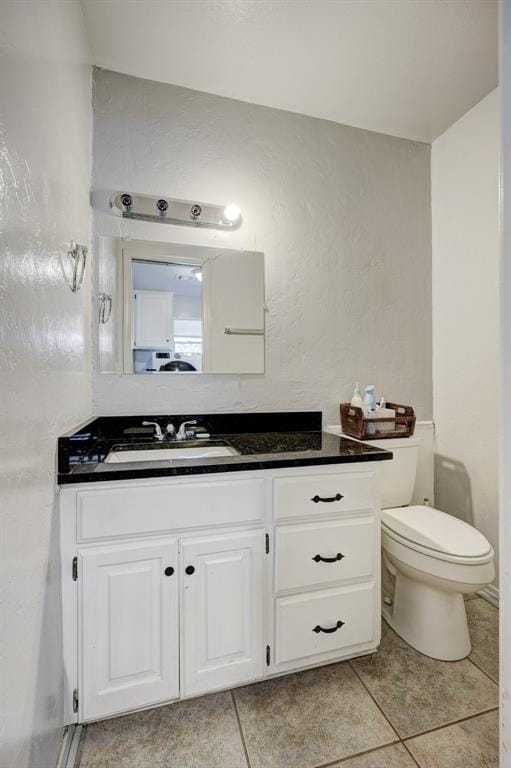 bathroom featuring toilet, tile patterned flooring, and vanity