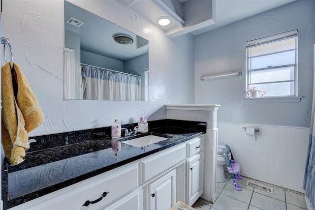 full bath featuring visible vents, toilet, a wainscoted wall, tile patterned floors, and vanity