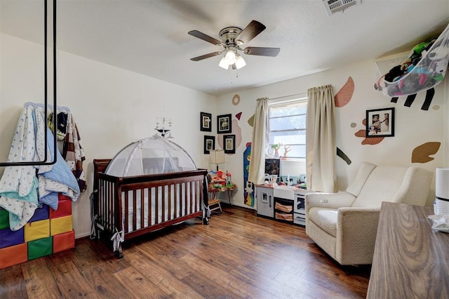 bedroom featuring baseboards, wood-type flooring, visible vents, and a ceiling fan