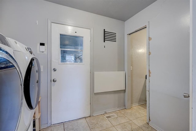 laundry area with light tile patterned floors, laundry area, washing machine and dryer, and visible vents