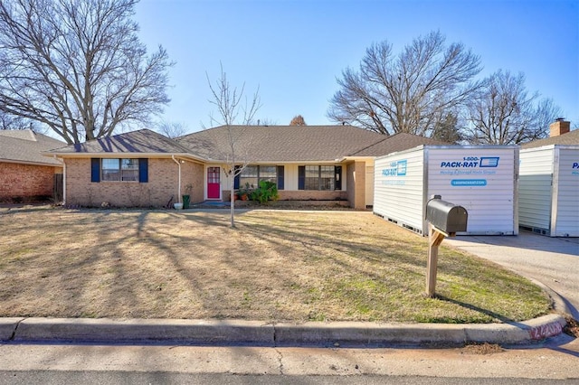 single story home with a front lawn and brick siding