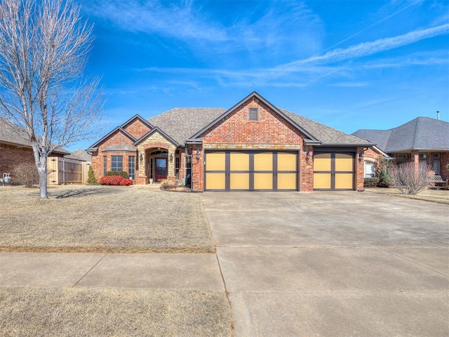 view of front of property featuring an attached garage, driveway, roof with shingles, and brick siding