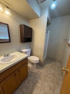 bathroom with visible vents, vanity, and toilet