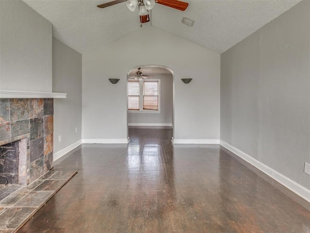 1817 NW 32nd St, Oklahoma City, OK 73118 - unfurnished living room featuring dark wood-type flooring, arched walkways, lofted ceiling, and baseboards