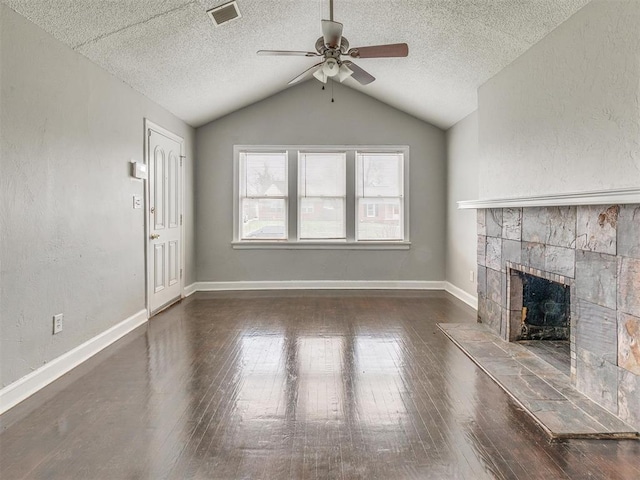 1817 NW 32nd St, Oklahoma City, OK 73118 - unfurnished living room featuring dark wood-style floors, lofted ceiling, visible vents, a fireplace with raised hearth, and baseboards