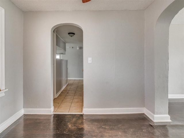1817 NW 32nd St, Oklahoma City, OK 73118 - empty room with baseboards, arched walkways, and a textured ceiling
