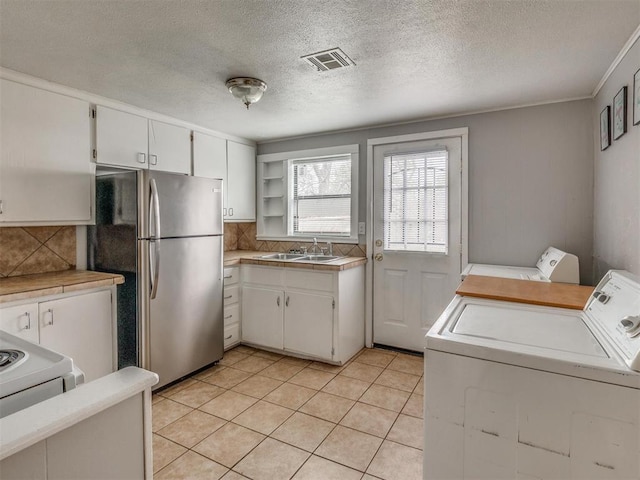 1817 NW 32nd St, Oklahoma City, OK 73118 - kitchen with a sink, visible vents, white cabinets, light countertops, and freestanding refrigerator