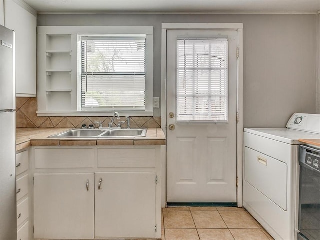 1817 NW 32nd St, Oklahoma City, OK 73118 - kitchen with white cabinets, washer / dryer, light countertops, and a sink