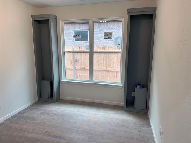 empty room featuring wood finished floors and baseboards