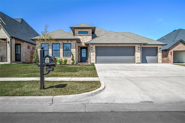 prairie-style home with a front yard, an attached garage, concrete driveway, brick siding, and roof with shingles