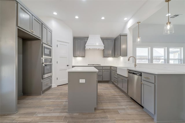 kitchen featuring recessed lighting, gray cabinets, a center island, stainless steel appliances, and decorative backsplash
