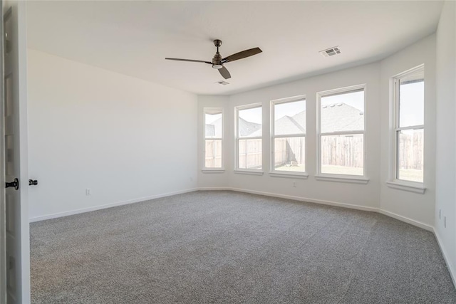 empty room featuring visible vents, baseboards, a ceiling fan, and carpet flooring