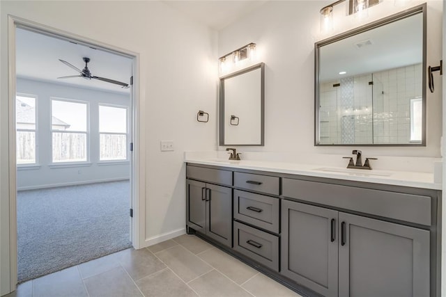 bathroom featuring a sink, baseboards, a ceiling fan, and a tile shower