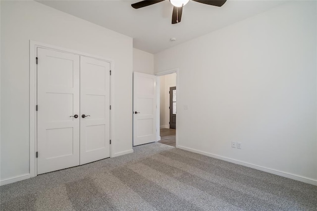 unfurnished bedroom with a closet, baseboards, a ceiling fan, and carpet flooring