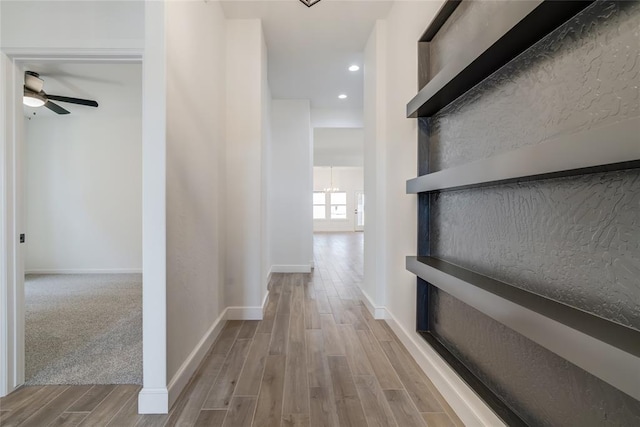 corridor featuring baseboards, recessed lighting, and wood finished floors