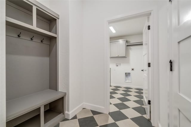 mudroom featuring baseboards and light floors