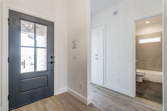 entryway with light wood-style flooring, plenty of natural light, and baseboards