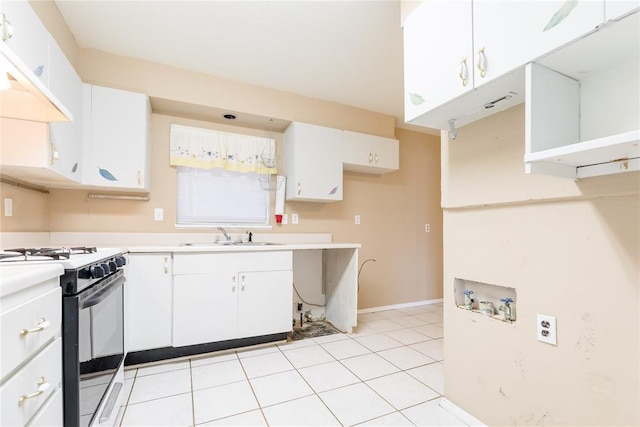 kitchen with a sink, gas range, white cabinets, and light countertops