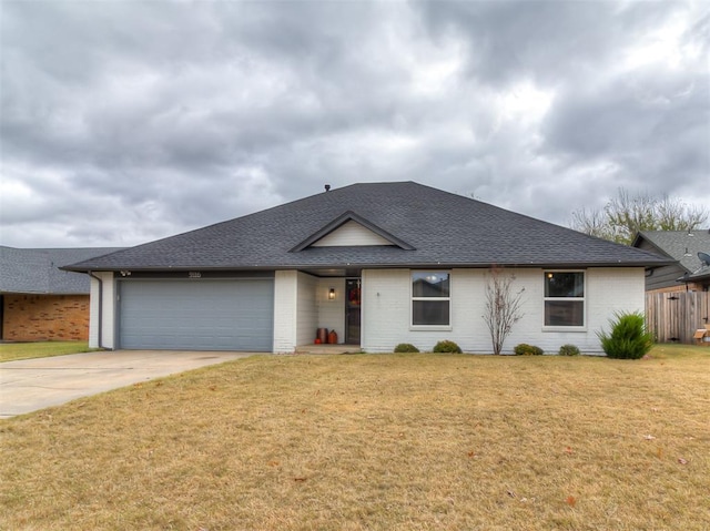 ranch-style home with a garage, brick siding, a front lawn, and roof with shingles