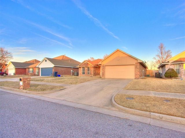 ranch-style home featuring brick siding, driveway, an attached garage, and central air condition unit