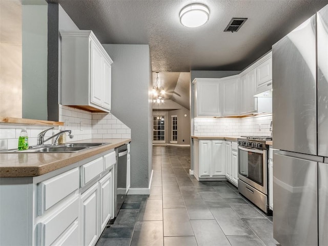 kitchen with under cabinet range hood, stainless steel appliances, a sink, visible vents, and white cabinets