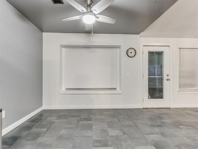 empty room with ceiling fan, visible vents, and baseboards