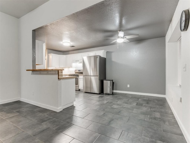 kitchen with baseboards, white cabinets, ceiling fan, appliances with stainless steel finishes, and a peninsula