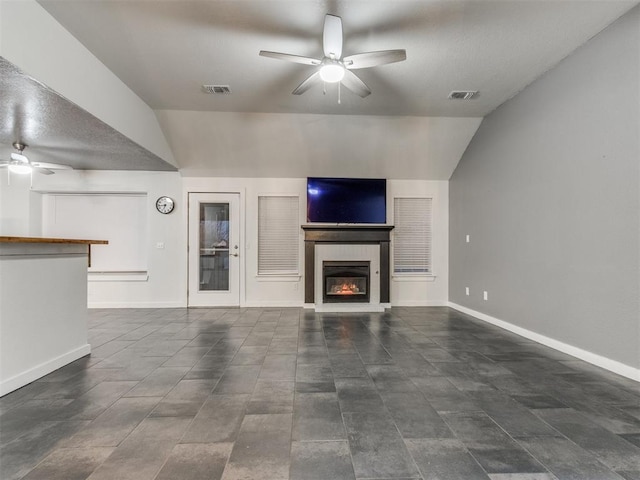 unfurnished living room with a large fireplace, visible vents, ceiling fan, and baseboards