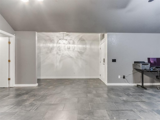 below grade area featuring baseboards, visible vents, and a notable chandelier