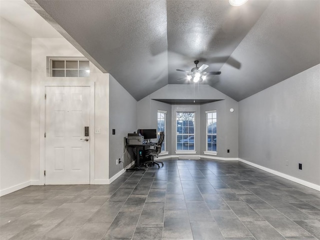 unfurnished office with lofted ceiling, a textured ceiling, a ceiling fan, and baseboards