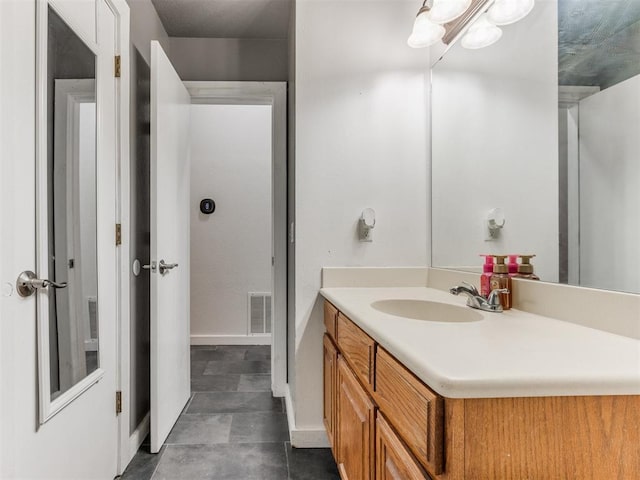 bathroom featuring vanity, visible vents, and baseboards