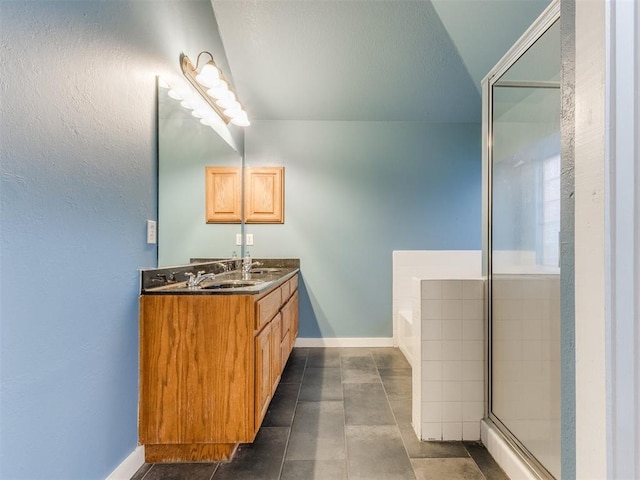 bathroom featuring a shower with door, double vanity, a sink, baseboards, and a bath