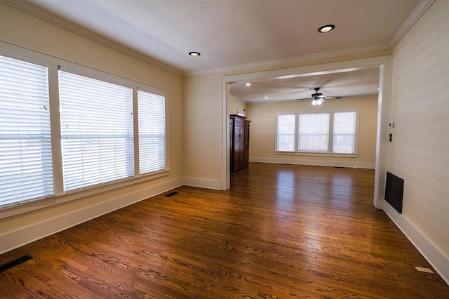 unfurnished living room with visible vents, a wealth of natural light, and ornamental molding