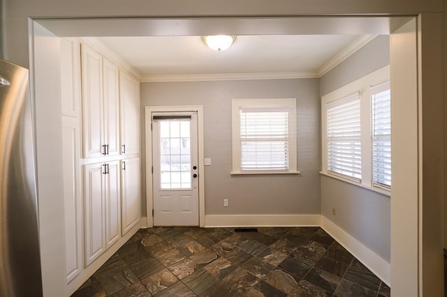 doorway with ornamental molding, stone finish floor, and baseboards