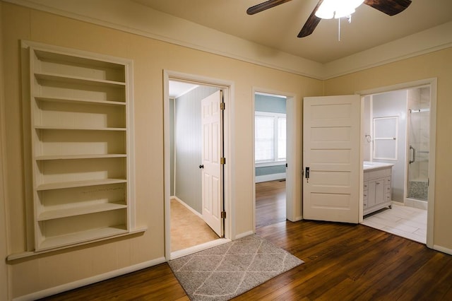 interior space with built in shelves, dark wood finished floors, and baseboards