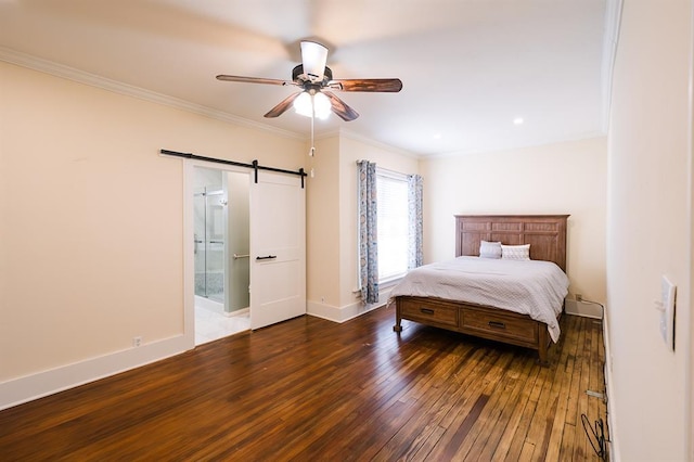 bedroom featuring crown molding, a barn door, dark wood-type flooring, connected bathroom, and baseboards