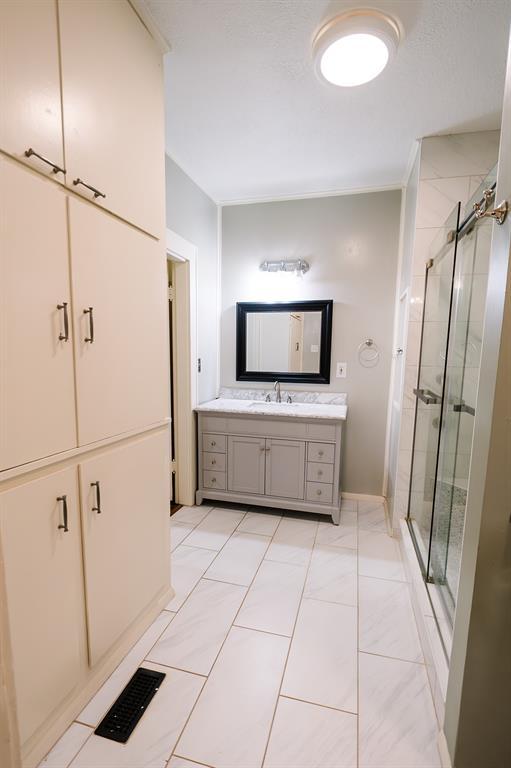 bathroom featuring a stall shower, visible vents, and vanity