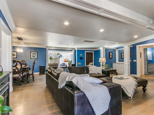 living area with visible vents, light wood finished floors, ornamental molding, and ornate columns