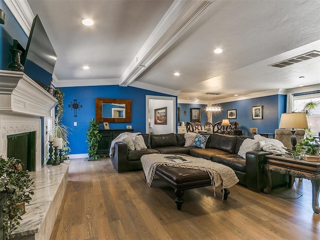 living room featuring a premium fireplace, visible vents, wood finished floors, and ornamental molding