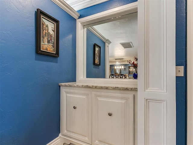 bathroom with a textured wall and visible vents