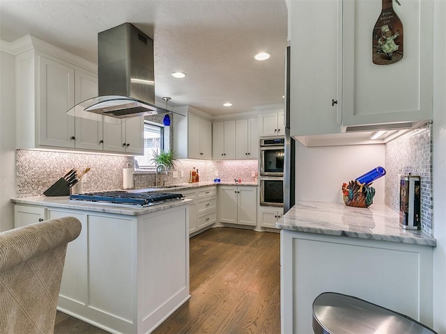 kitchen with dark wood finished floors, island exhaust hood, white cabinetry, and stainless steel appliances