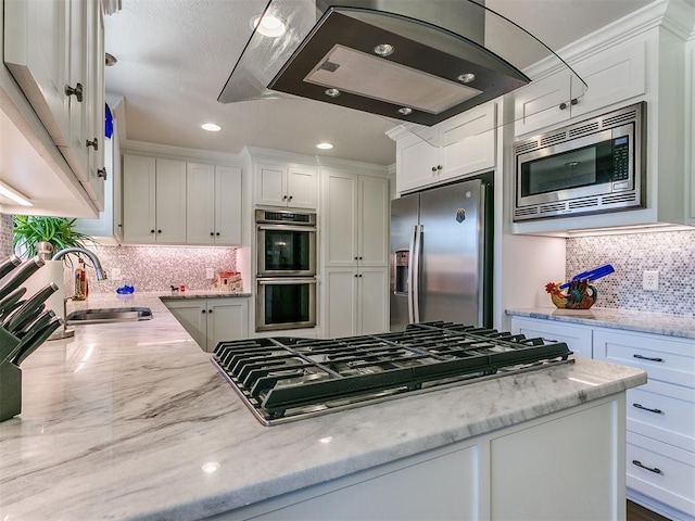 kitchen with a sink, light stone counters, stainless steel appliances, white cabinets, and extractor fan