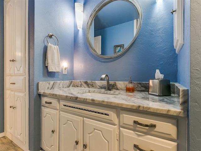 bathroom with vanity and a textured wall