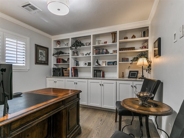 office featuring visible vents, crown molding, and light wood finished floors