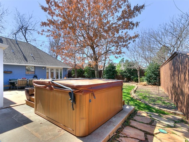 exterior space with a patio area, a fenced backyard, and a hot tub