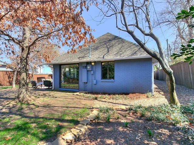 back of property featuring a patio area, brick siding, fence private yard, and a shingled roof