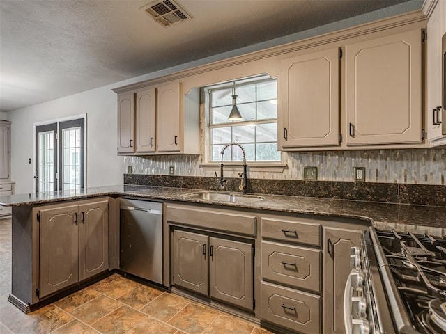 kitchen featuring stainless steel appliances, a wealth of natural light, visible vents, a sink, and a peninsula