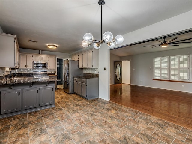 kitchen with dark countertops, a peninsula, visible vents, and stainless steel appliances