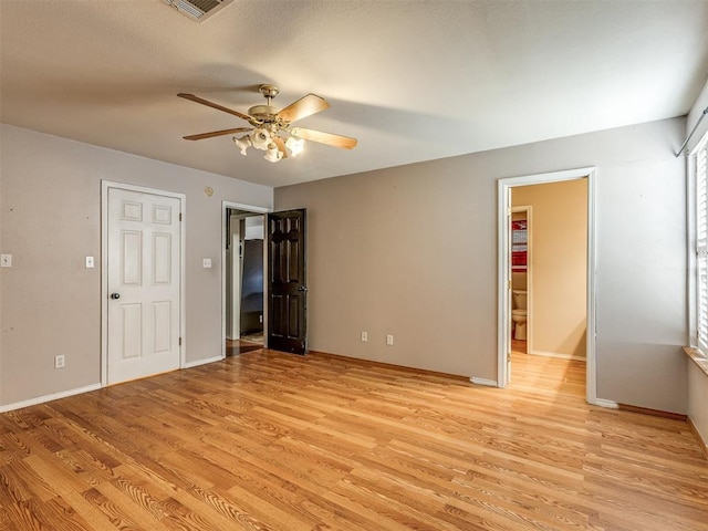 unfurnished room with light wood finished floors, ceiling fan, visible vents, and baseboards