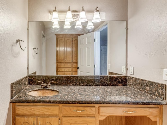 bathroom featuring a textured wall and vanity